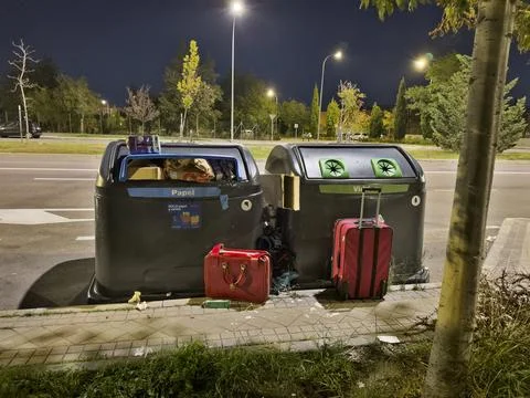 A trash can with a suitcase inside of it Foto stock