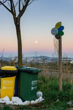 Trash cans lined up next to each other at sunset with the moon. Empremasa Stock Photos
