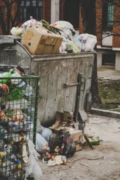 Trash dumpster being overfull with garbage in the city, vertical image. 스톡 사진