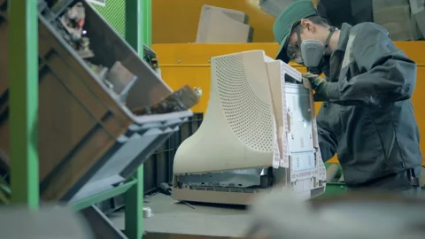 Trash, e-waste, electronic garbage recycling factory. A person takes apart an Stock Footage 135663048