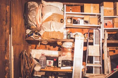 Trash in the garage, piled up different old things 库存照片