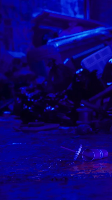 Trash lies on the ground in a dark space with purple lighting during late hours Stock Footage 331760692