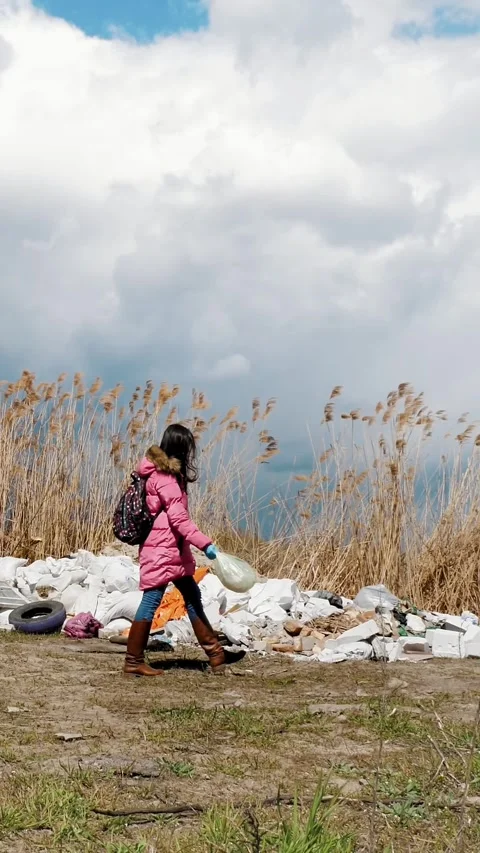 Trash outdoors. garbage dump near the river. woman, volunteer, with plastic Stock Footage 317704352