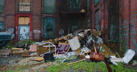 Trash pile behind graffiti covered mill building in the rain 動画素材 239291057