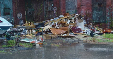 Trash pile behind graffiti covered mill building in the rain 動画素材 239292824