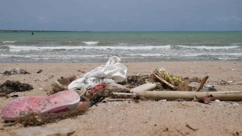 Trash washed ashore by ocean waves, caused by human pollution.  Stock Footage 310680372