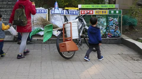 Trash worker cleaning public recycle bins and mother and sons recycling Stock Footage 43043276