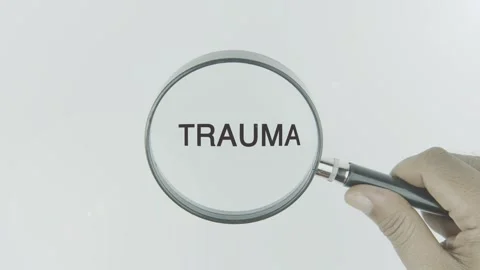 Trauma text or word highlighted by a magnifying glass in a hand Stock Footage 303808227