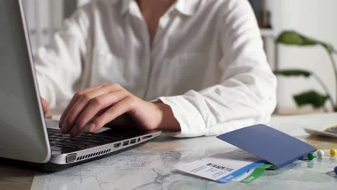 Travel agency agent manager working on a portable laptop making out a trip f Stock Footage 202097169