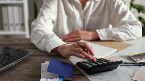 A travel agent counts on a calculator the cost of tickets, coupons for a fli Video stock 200016838