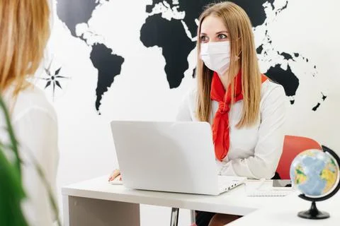 Travel agent working with client in light modern office of tour agency, 写真素材
