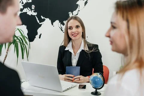Travel agent working with client in light modern office of tour agency, Foto stock
