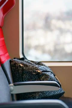 Travel Backpack Resting on Empty Train Seat Near Window Light Foto stock