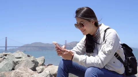 Travel backpacker resting on rock texting message Stock Footage 100951625