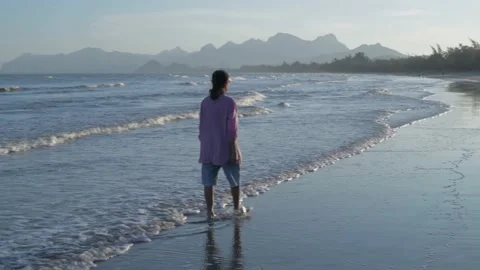 Travel concept of 4k Resolution. An old woman walking on the beach. Stock Footage 146710059