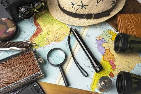 Travel concept, geographical map, magnifier and binoculars, hat and camera Stock Photos