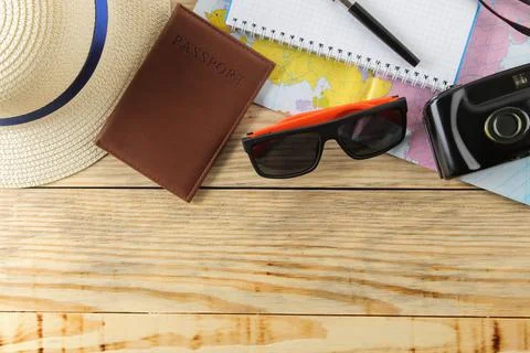 Travel concept A map, camera, passport, and glasses on a natural wooden table Stock Photos
