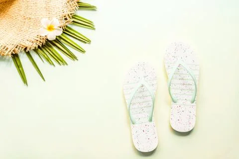 Travel flat lay items: beach slippers, straw hat and palm leaf. Place for tex Stock Photos