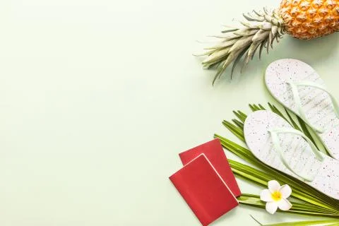 Travel flat lay items: two passports, fresh pineapple, beach slippers Foto stock