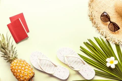 Travel flat lay items: two passports, fresh pineapple, sunglasses, beach slip Stock Photos