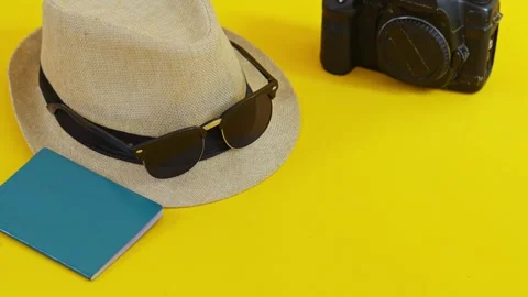 Travel flat lay with straw hat, sunglasses, vintage camera, and passport on Video stock 331160140