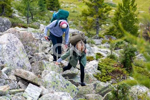 Travel Lifestyle and survival concept rear view. Hiking women with backpack Stock Photos