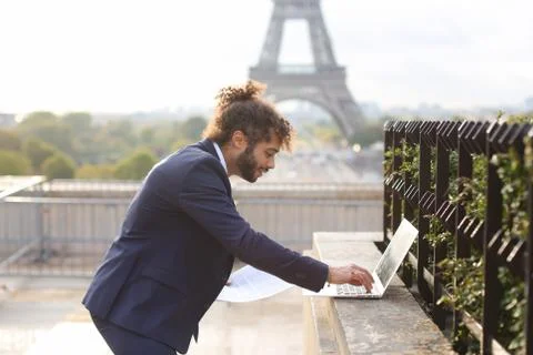 Travel manager using laptop with Eiffel Tower in background in s 写真素材