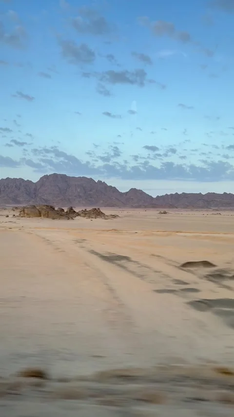 Travel scene featuring motion blurred vehicle view over vast rocky desert Stock Footage 324807431