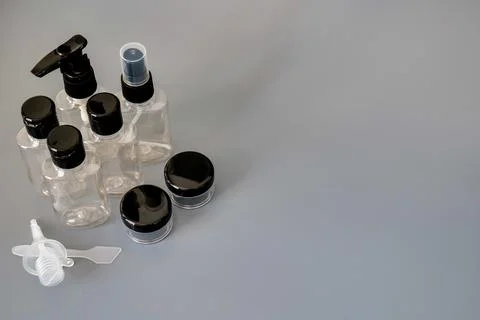Travel size empty plastic bottles and containers for toiletries on gray Stock Photos