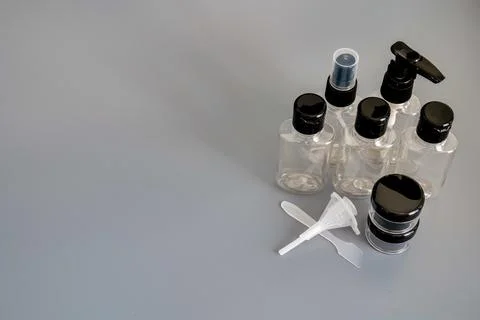 Travel size empty plastic bottles and containers for toiletries on gray Stock Photos