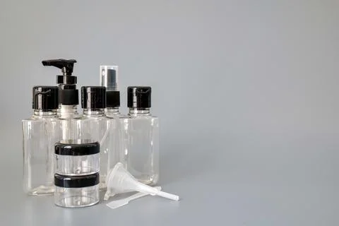 Travel size empty plastic bottles and containers for toiletries on gray Stock Photos