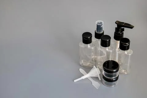 Travel size empty plastic bottles and containers for toiletries on gray Stock Photos