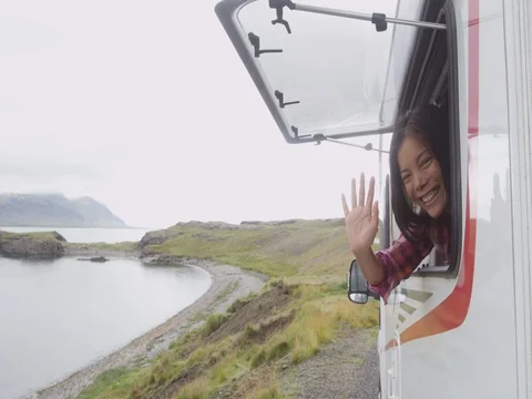 Travel woman in mobile motor home RV campervan waving hand saying hello hi Stock Footage