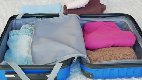 Beautiful Woman Packing Suitcase In Bedroom Getting Ready For Road