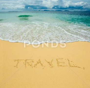 Travel written in a sandy tropical beach Stock Photos