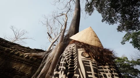 Traveler admiring massive ancient tree roots at Angkor Wat temple ruins Stock Footage 335369325