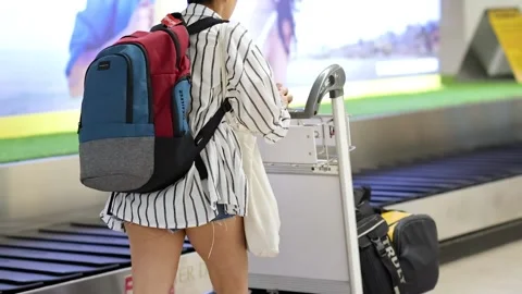 Traveler with Backpack at Baggage Carousel Stock Footage 308439592