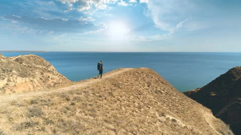 The traveler with backpack walks on the mountain range on the beautiful seascape Stock Footage 143040035