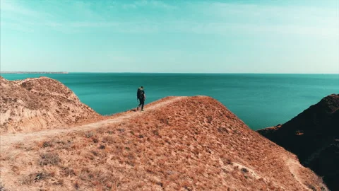 The traveler with backpack walks on the mountain range on the beautiful seascape Video stock 151367657