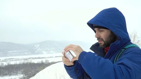 Traveler With a Beard Using Smartphone On Mountain. Stock Footage 73423352