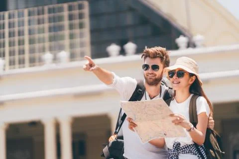 Traveler couple using local map, happy traveling together Stock Photos