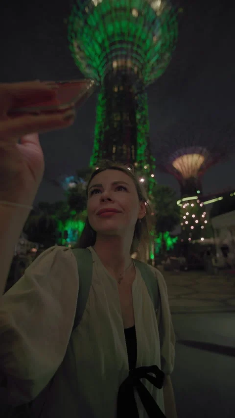 Traveler glowing tree lighting performance on phone at Gardens by the Bay Stock Footage 343671619