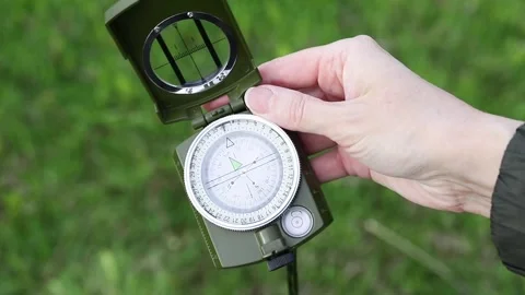 Traveler opens a compass and uses it to navigate the outdoors Stock Footage 341950673