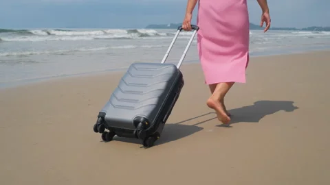 Traveler pulling suitcase, walking along shore Vídeos de archivo 333098981