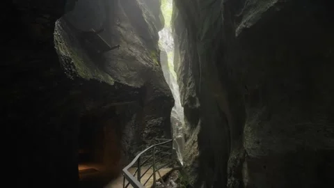 Traveler silhouette walking through dramatic gorge in Swiss Alps Stock Footage 320103477