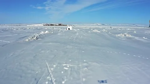 Traveler silhouettes construct igloo with ice blocks aerial Stock Footage 132290577