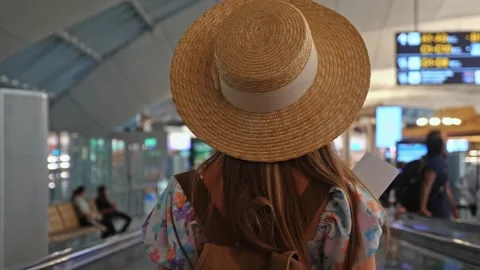 Traveler in straw hat walking in airport holding passport Vídeo Stock 334226653