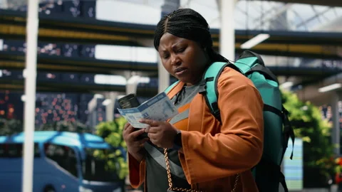 Traveler studies bus ticket using smartphone to confirm planned connection Stock Footage 340201785