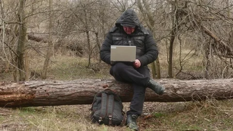 Traveler typing something on a laptop while sitting on a lying pine 스톡 동영상 175062020