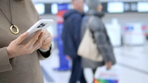 Traveler uses smartphone while waiting at airport Stock Footage 341508009